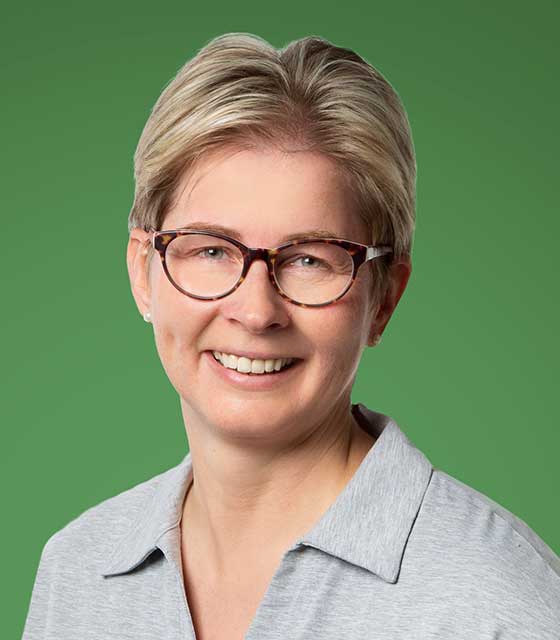 Baumberge Verein Eine Frau mit Brille lächelt auf grünem Hintergrund.