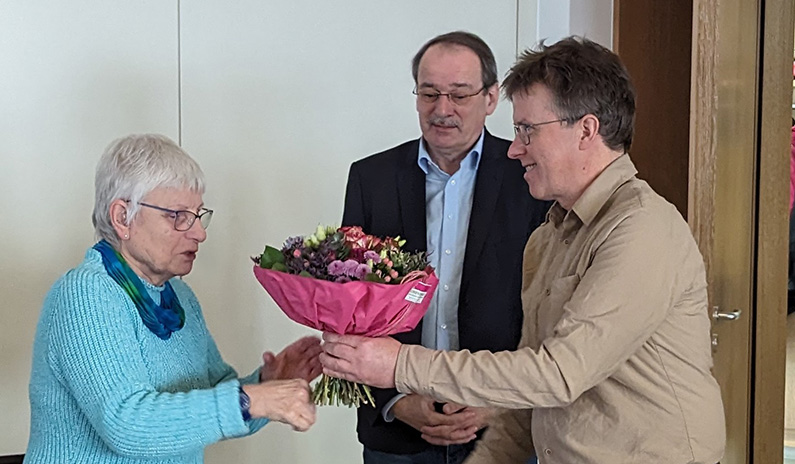 Baumberge Verein Eine Frau erhält Blumen von einem älteren Mann.