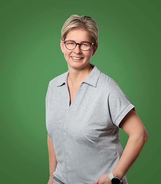 Baumberge Verein Eine Frau mit Brille lächelt auf grünem Hintergrund.